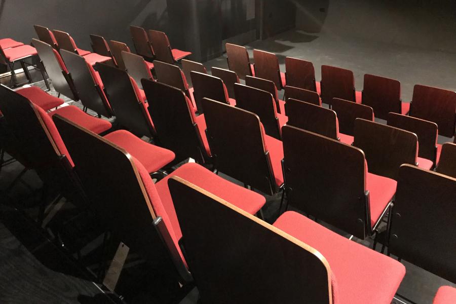 Red chairs in a black box theatre