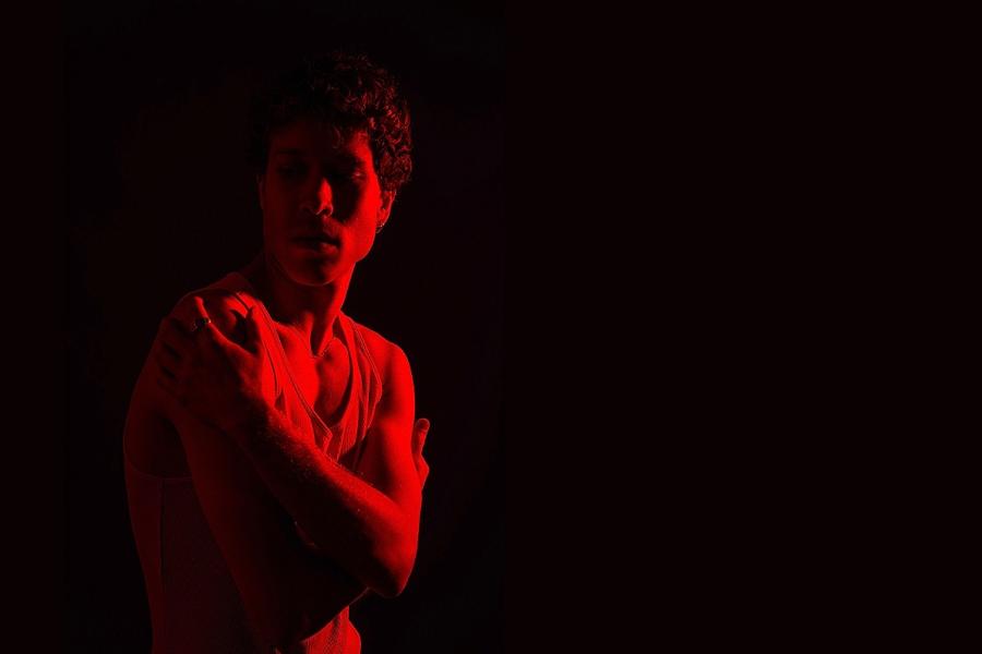 Picture of the performer in a red light followed by the title of the piece 