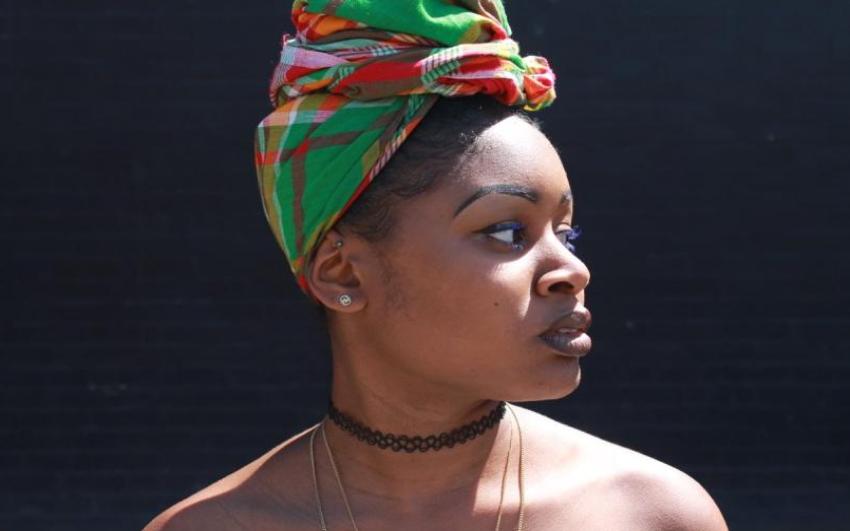 A performer in a colourful headscarf photographed in side profile