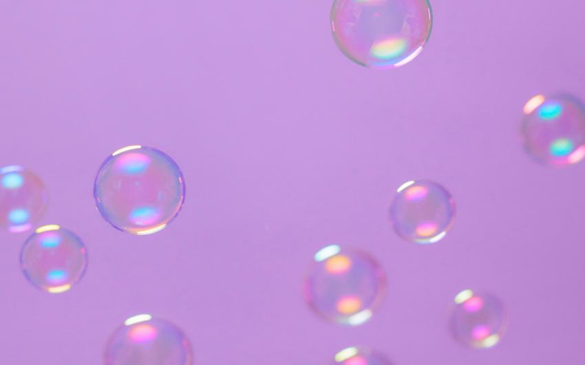 Transparent bubbles glistening against a pastel purple background