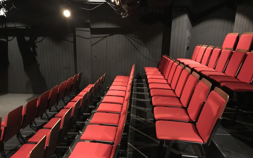 Rows of red upholstered chairs in a theatre
