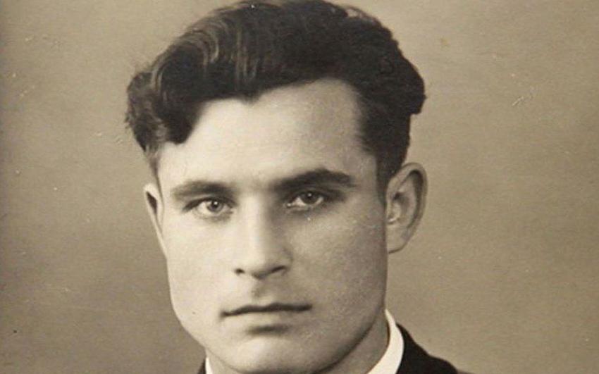 Portrait of Vasili Arkhipov wearing a dark Soviet naval uniform with medals, looking directly at the camera with a calm, serious expression against a plain background.  