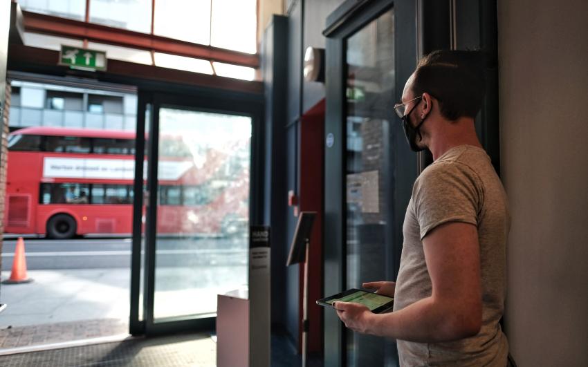 A photo of a CPT staff member looking out towards the automatic doors of the theatre, facing the street 
